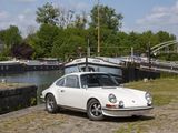 a white car parked on the side of the road next to the water
