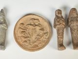 Plusieurs objets anciens sont exposés sur une surface blanche