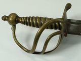 a close up of a sword on a white surface
