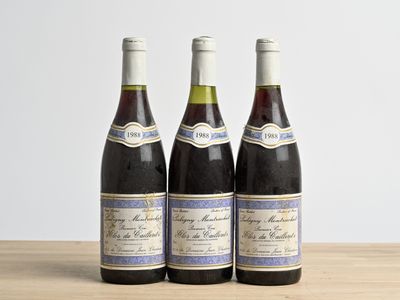 three bottles of wine sitting on top of a wooden table