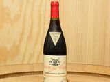 une bouteille de vin posée sur un tonneau en bois