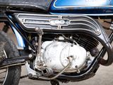 a close up of a blue motorcycle parked on the side of the road