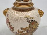 a white and gold vase with a bird on it