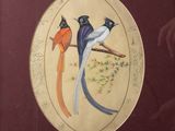 three birds sitting on a branch on a plate