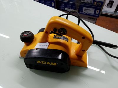 une ponceuse filaire posée sur une table dans un magasin