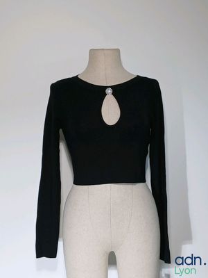 un mannequin vêtu d'un haut noir et d'un pantalon blanc, sur un mannequin