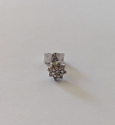 gros plan d'une bague en argent sur une surface blanche