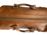 a brown leather bag that is sitting on a white surface