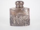 an antique silver flaskt with a scene of soldiers on it