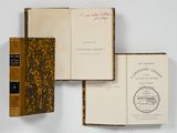 trois livres sont empilés sur une surface blanche