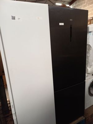 un réfrigérateur noir et blanc à côté d'un lave-linge et d'un sèche-linge