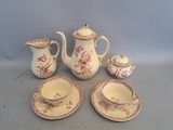 a tea pot, cup, saucer, and saucer on a table