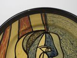 a plate with a painting of a woman ' s face on it