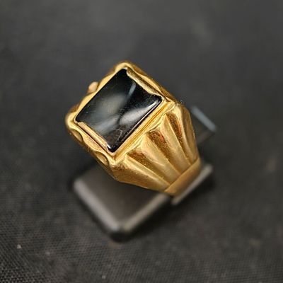 une image représentant une bague en or sertie d'une pierre noire