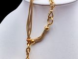 an image of a gold necklace with a pink stone on it