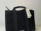 the small black bag is sitting on the table with a tag attached to it