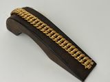 a close up of a gold chain bracelet on a wooden stand