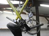 a yellow bike hanging from the ceiling of a garage