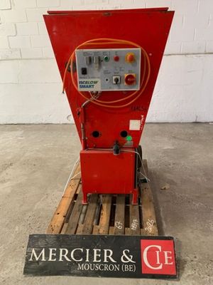une machine rouge posée sur une palette dans un entrepôt