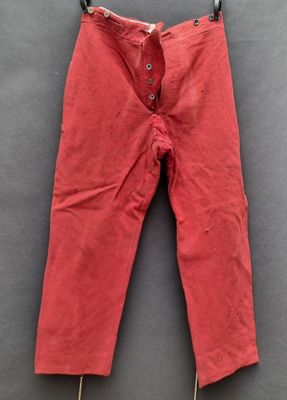 un pantalon rouge suspendu à une corde à linge