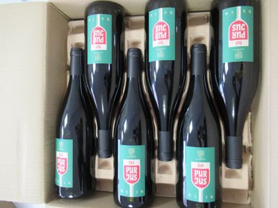 six bottles of red wine in a box with a stop sign on the label