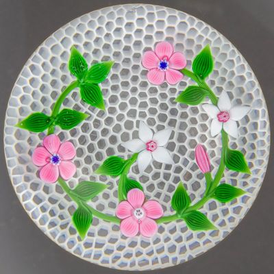 une assiette blanche décorée de fleurs roses et de feuilles vertes