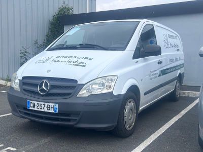 une camionnette blanche garée sur un parking à côté d'un bâtiment