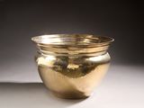 a gold bowl sitting on a table with a black background