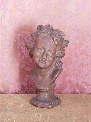 a small statue of a child with curly hair on a table