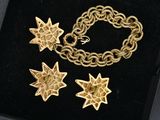 gold plated bracelet and earrings with star charms in a black box