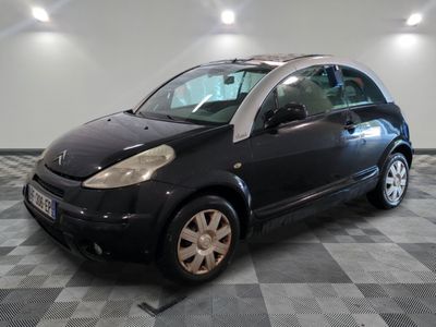 la photo d'une petite voiture noire sur un sol en damier