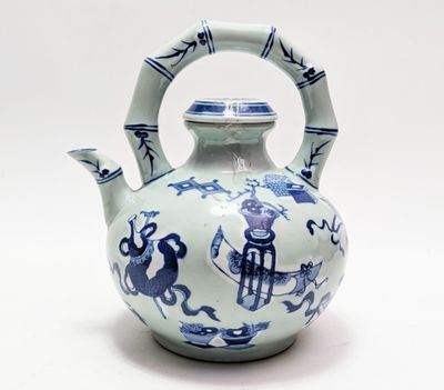 une théière bleue et blanche munie d'une anse