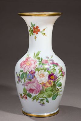 un vase orné de fleurs peintes, posé sur une table