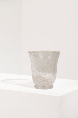 un vase en verre posé sur un socle blanc dans une pièce