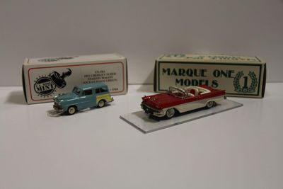 Deux petites voitures sont assises l'une à côté de l'autre sur une table.