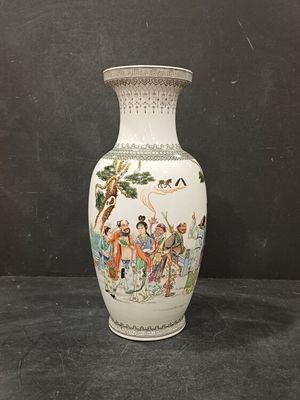 a white vase with a painting on it sitting on a table