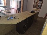 une photo d'un bureau avec un bureau et une grande fenêtre