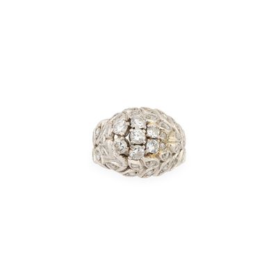un gros plan d'une bague avec une boule en diamant sur fond blanc