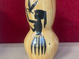 un vase en bois orné d'une image représentant une femme et un oiseau