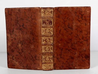 un vieux livre à la couverture brune posé sur une table