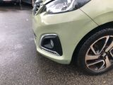 a close up of a green car parked in a parking lot