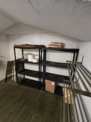 une pièce dans laquelle se trouve une étagère sur laquelle sont posés tout un tas d'objets