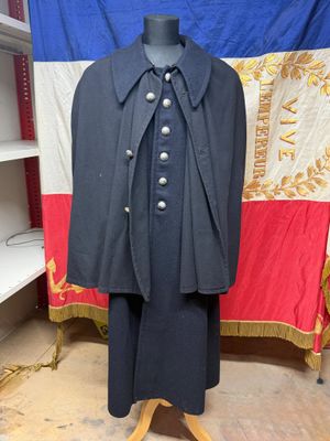 une image représentant un manteau posé sur un mannequin devant un drapeau