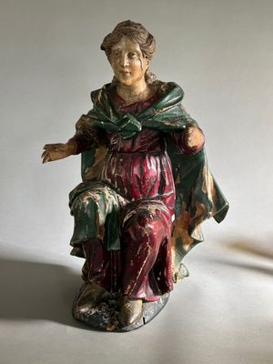 une figurine de femme assise sur une chaise