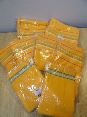four bags of yellow plastic bags sitting on top of a wooden table
