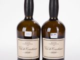 deux bouteilles de vin posées l'une à côté de l'autre sur une surface blanche