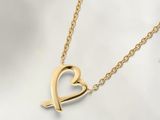 un collier en or orné d'un cœur et d'une flèche
