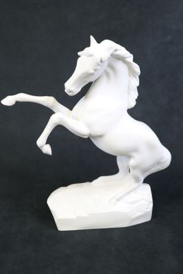 une statue blanche représentant un cheval debout sur ses pattes arrière