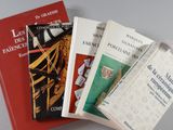 trois livres sont empilés sur une table