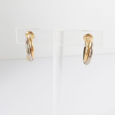 a pair of gold hoop earrings on a clear stand